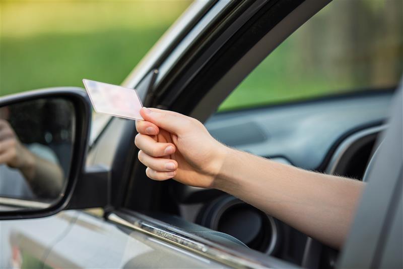 Driver giving their license to a police officer during a DUI stop