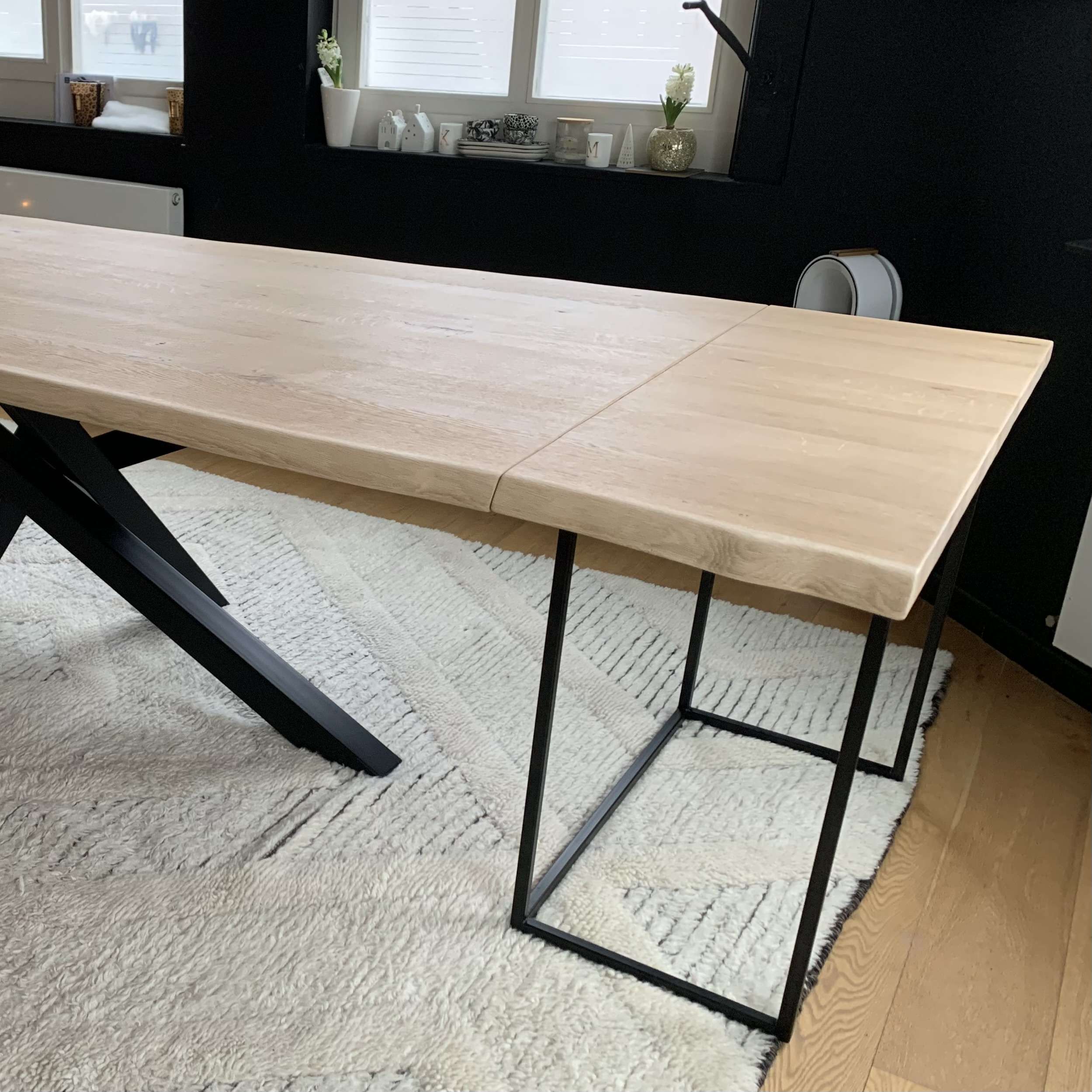 Table extensible design en chêne massif de Tableàpart avec une rallonge sous forme de console, dans une salle à manger.