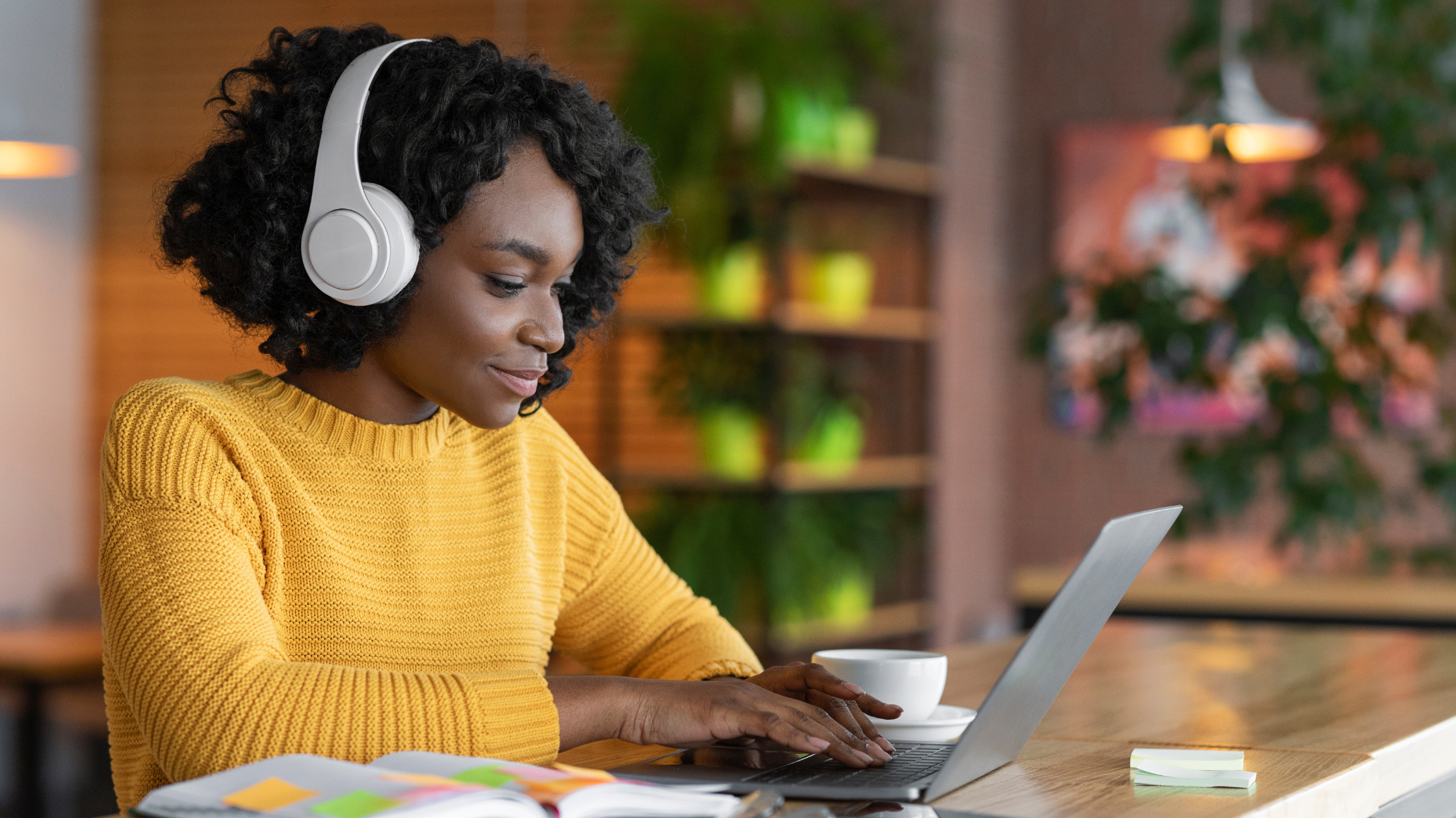 A student using a laptop and wearing headphones, using Tailo's AI summarisation and text-to-speech.