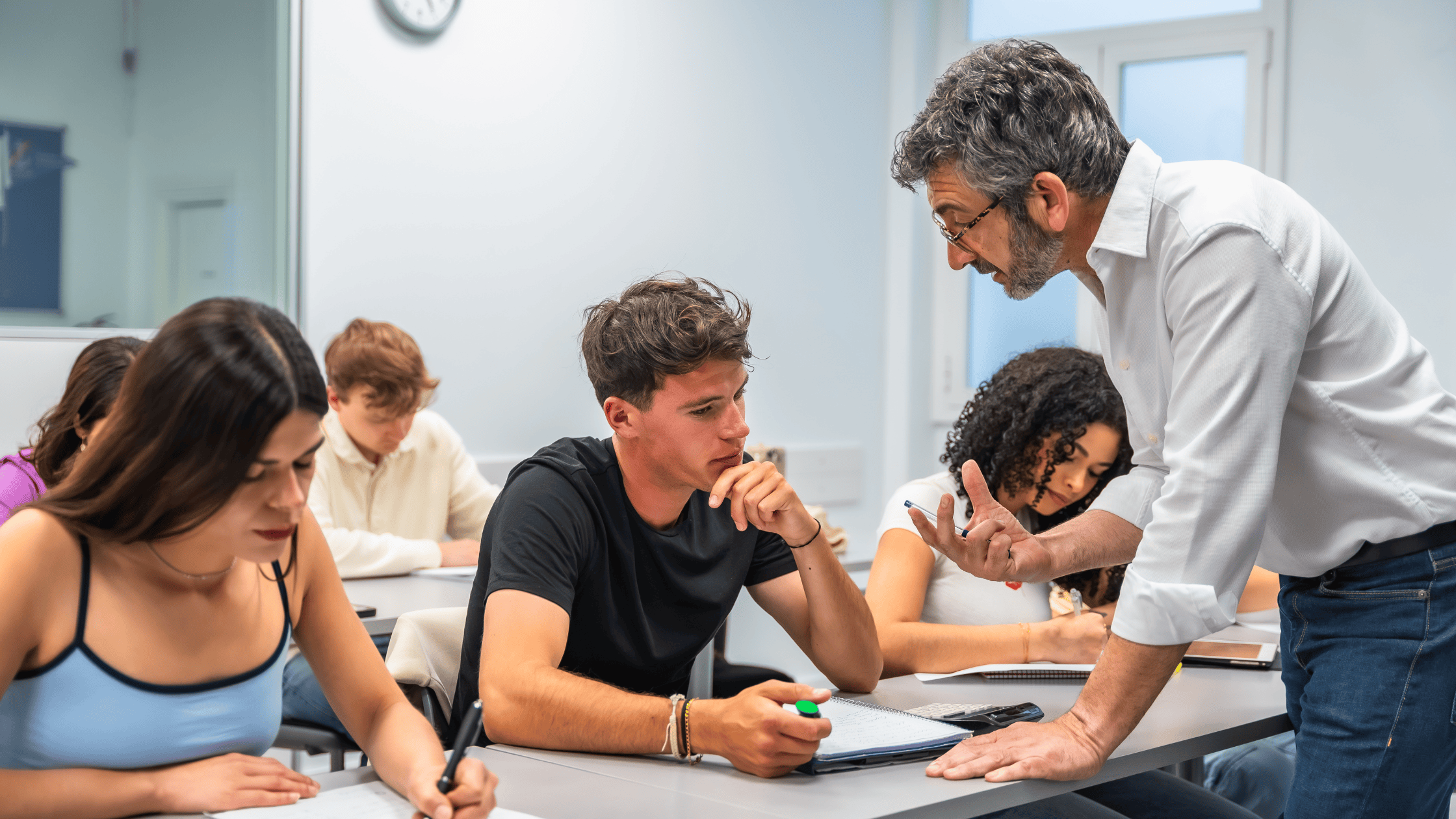Photograph of a group of students sat in a lecture hall, taking notes.
