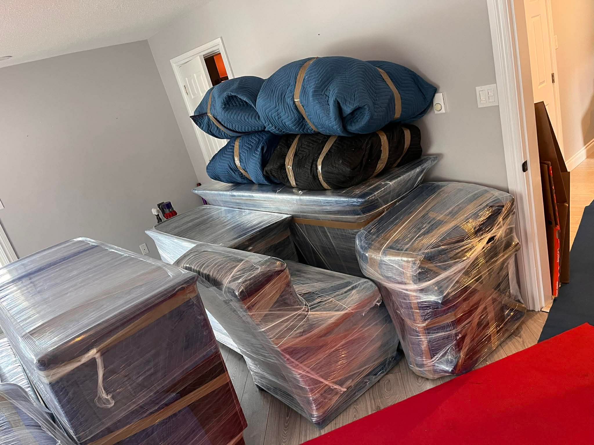 Furniture wrapped in protective film and moving blankets before transport