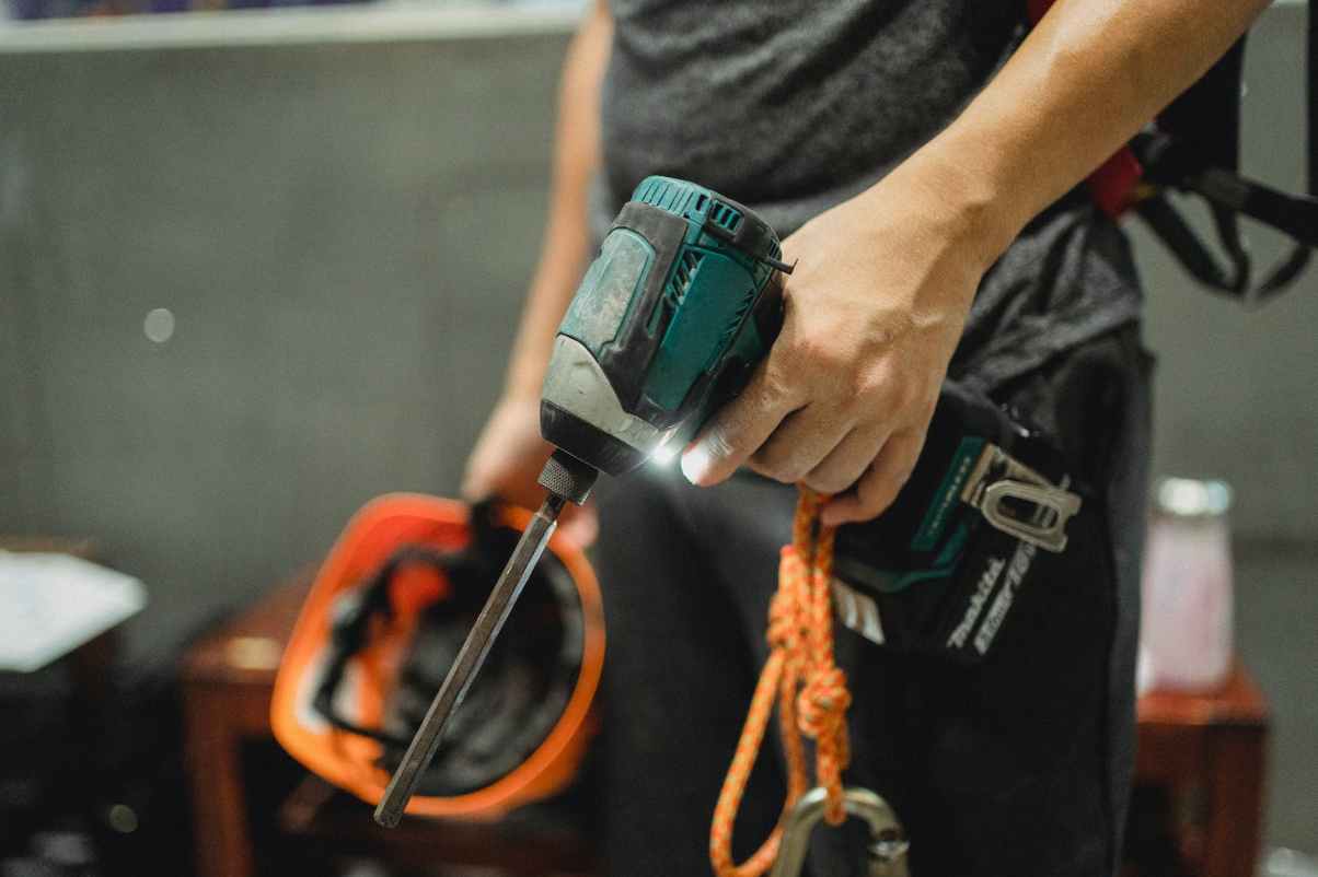 crop repairman standing with working screwdriver and orange helmet