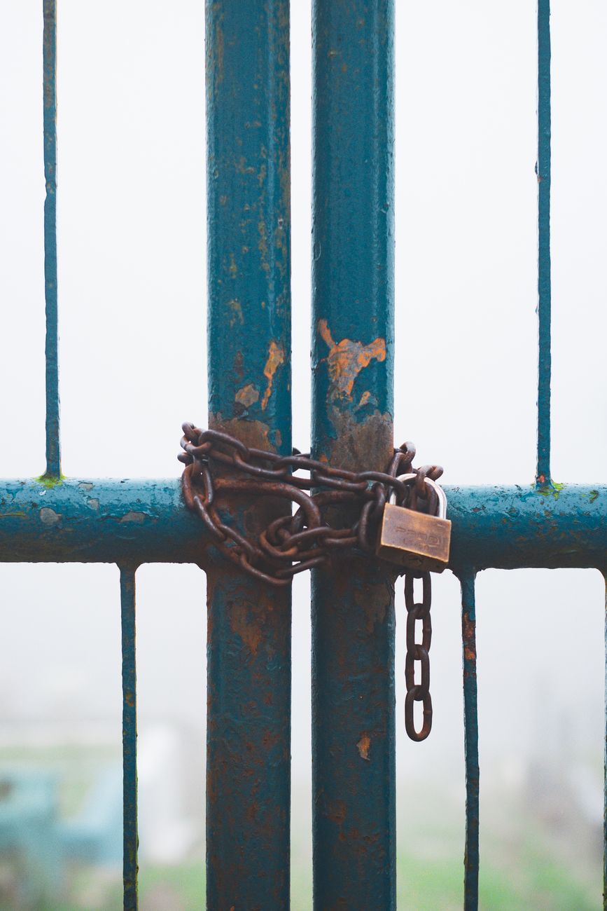 a rusty chain and a padlock on a gate
