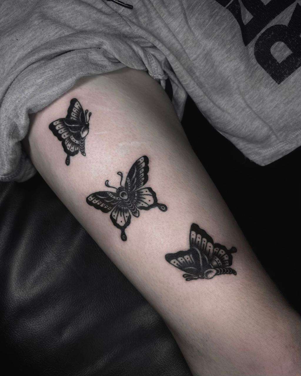 black & grey blackwork tattoo of butterfly on the upper arm