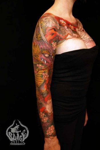Tatuaje Japones De Un Dragon Y Flores En El Brazo De Una Mujer