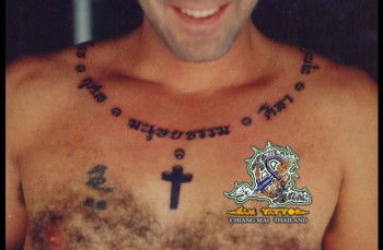 Tatuaje De Una Frase Tailandesa Rodeando El Cuello Y Una Cruz