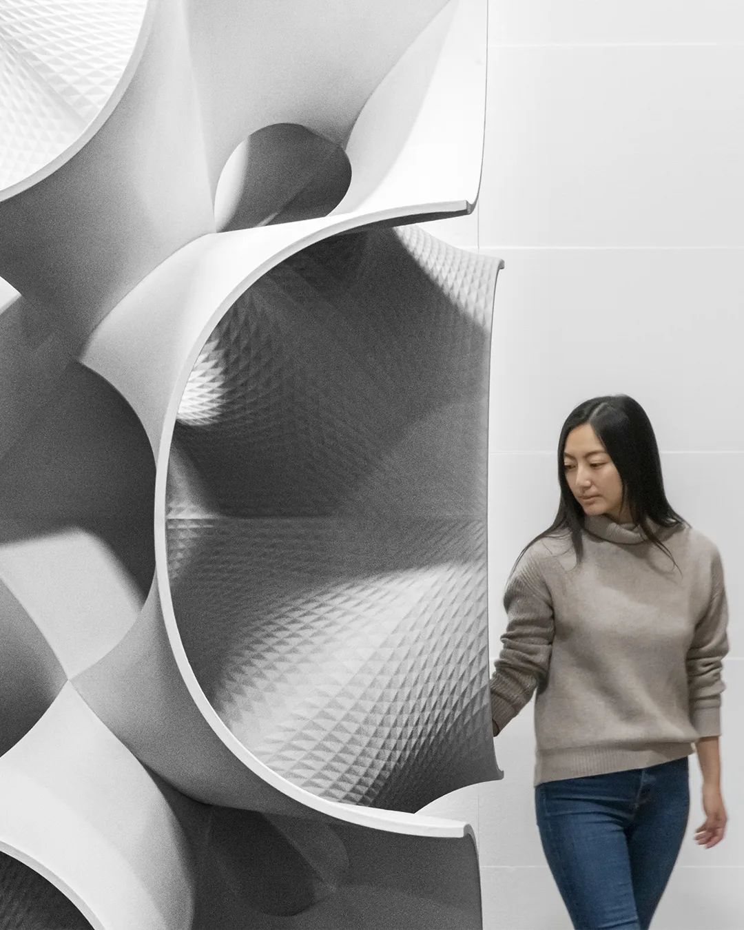 A 3d printed minimal surface used for concrete formwork, with a human standing next to it for scale