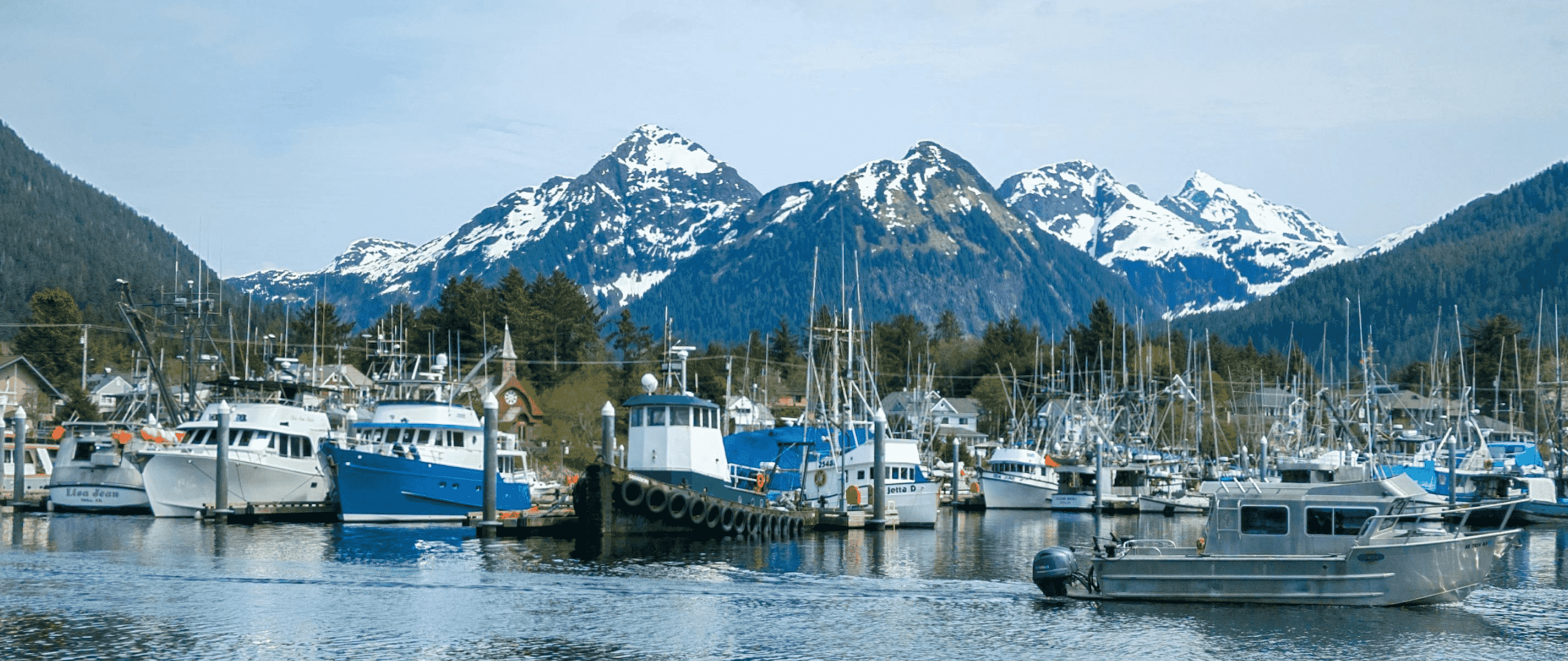 Alaska Scenery - Boats docked at Sitka harbor with snow-capped mountains in the background, Alaska