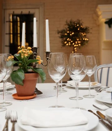 Elegant dining table set with wine glasses, candles, and a flower centerpiece at T Branch Kitchen.