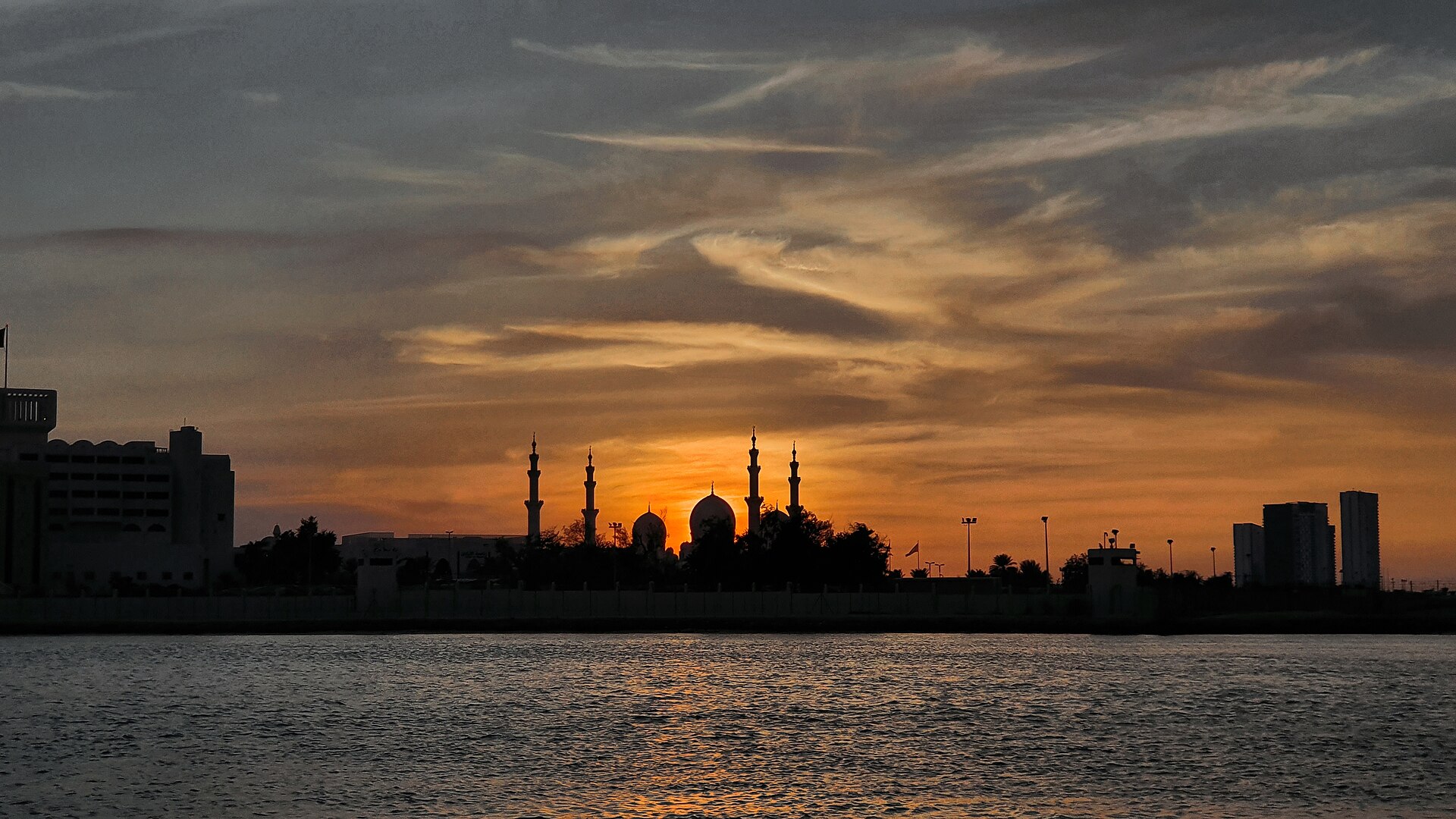 White marble courtyard and minarets of the Sheikh Zayed Grand Mosque in Abu Dhabi at dusk