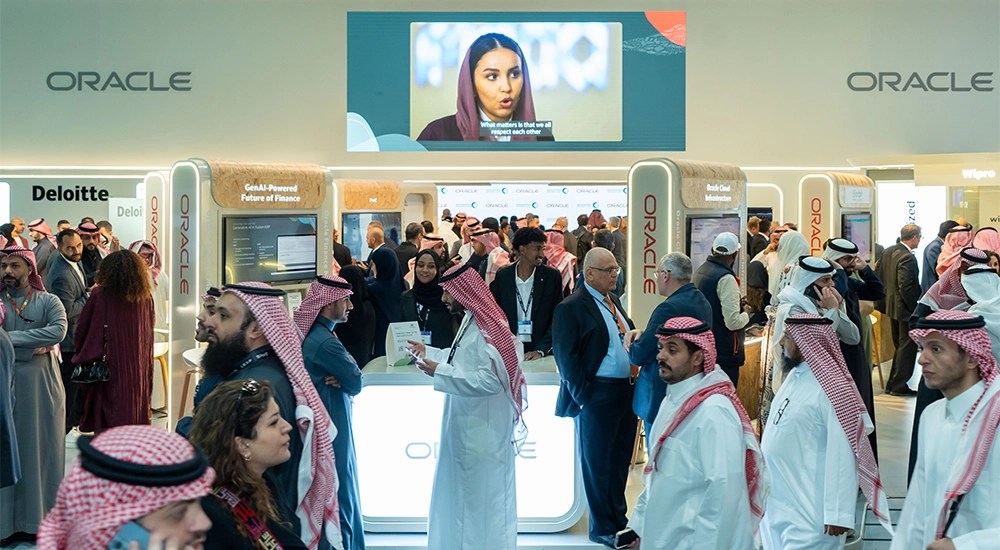 Oracle's LEAP booth in Riyadh with Oracle Cloud Infrastructure branding and a crowd of attendees in traditional Saudi dress