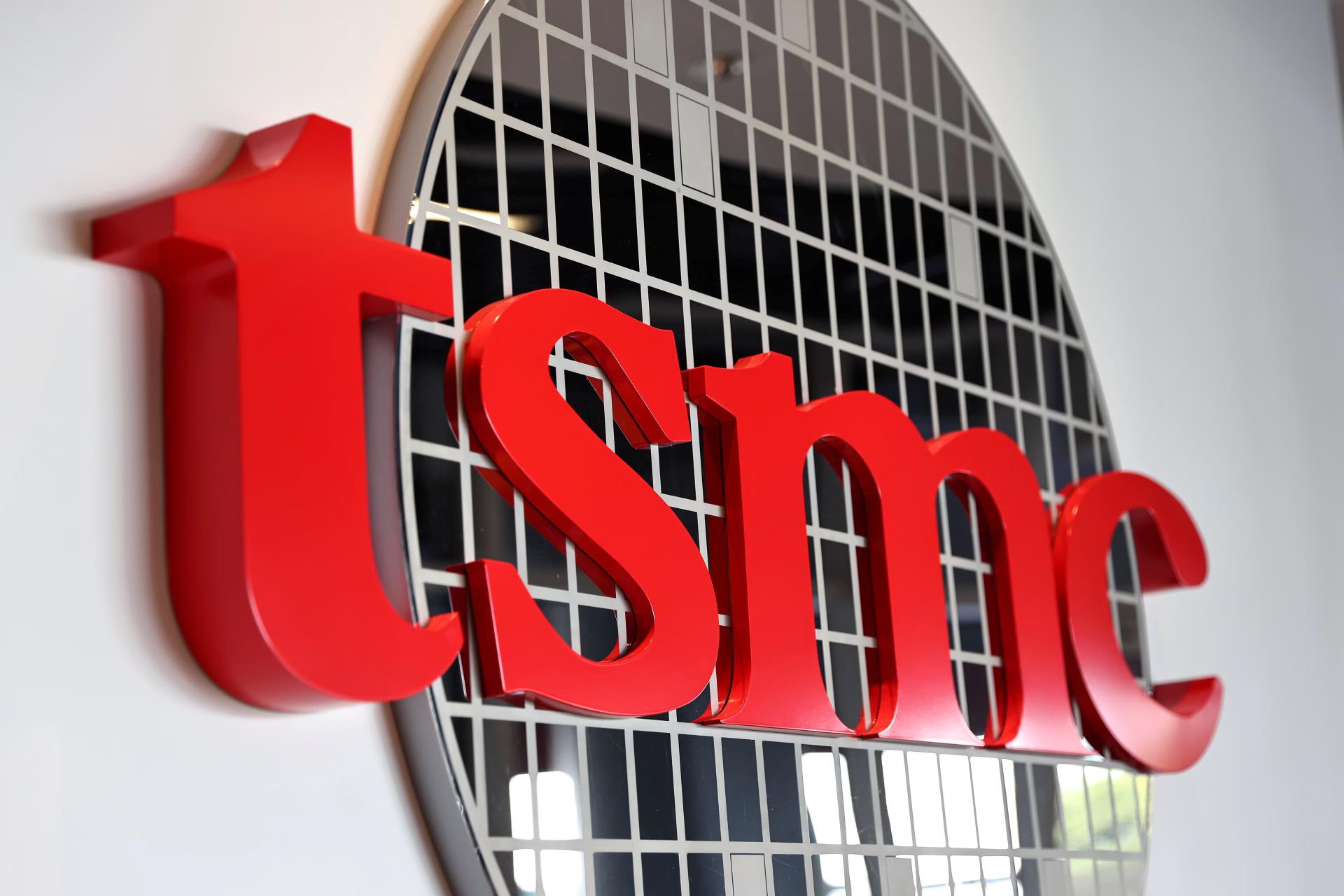 TSMC logo in front of a patterned silicon wafer graphic