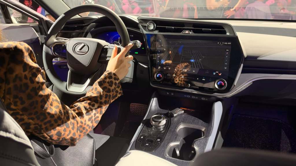 Interior view of a Lexus car showing the steering wheel and dashboard with a touchscreen display.