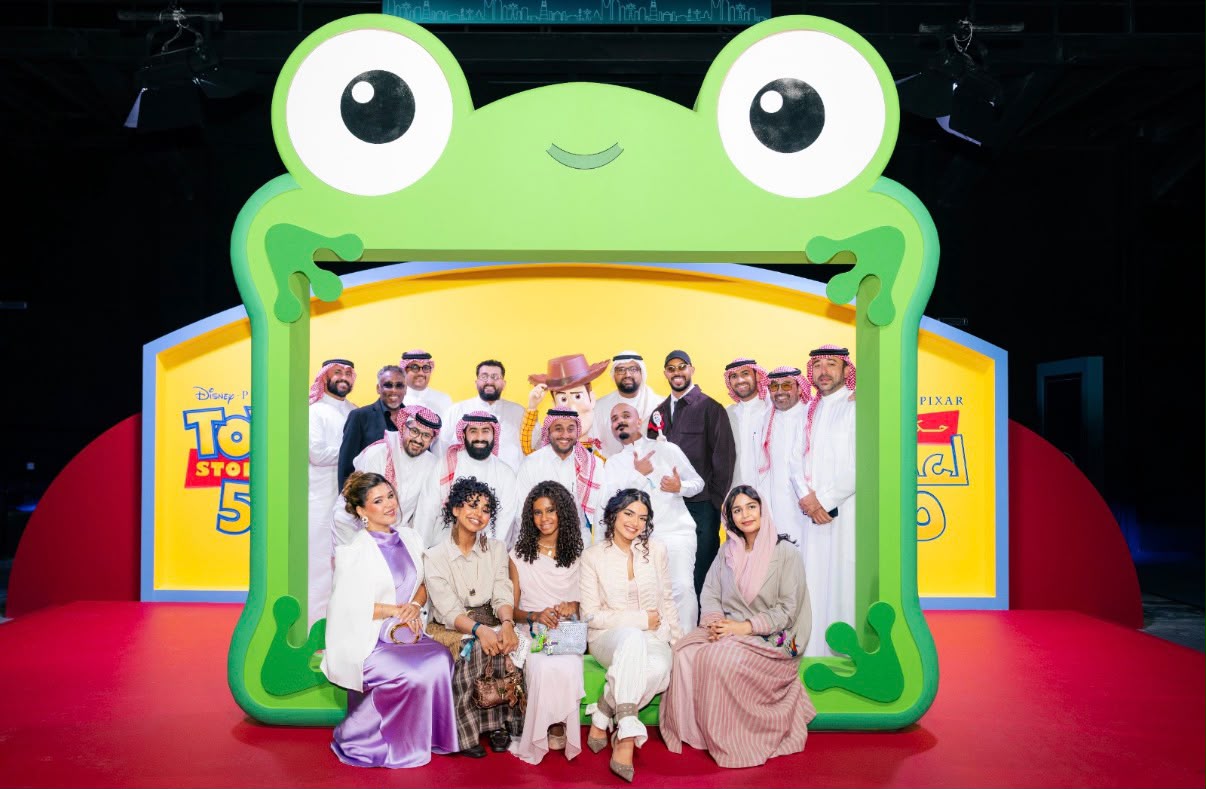 A group poses beneath Toy Story 5 branding at the Riyadh launch event