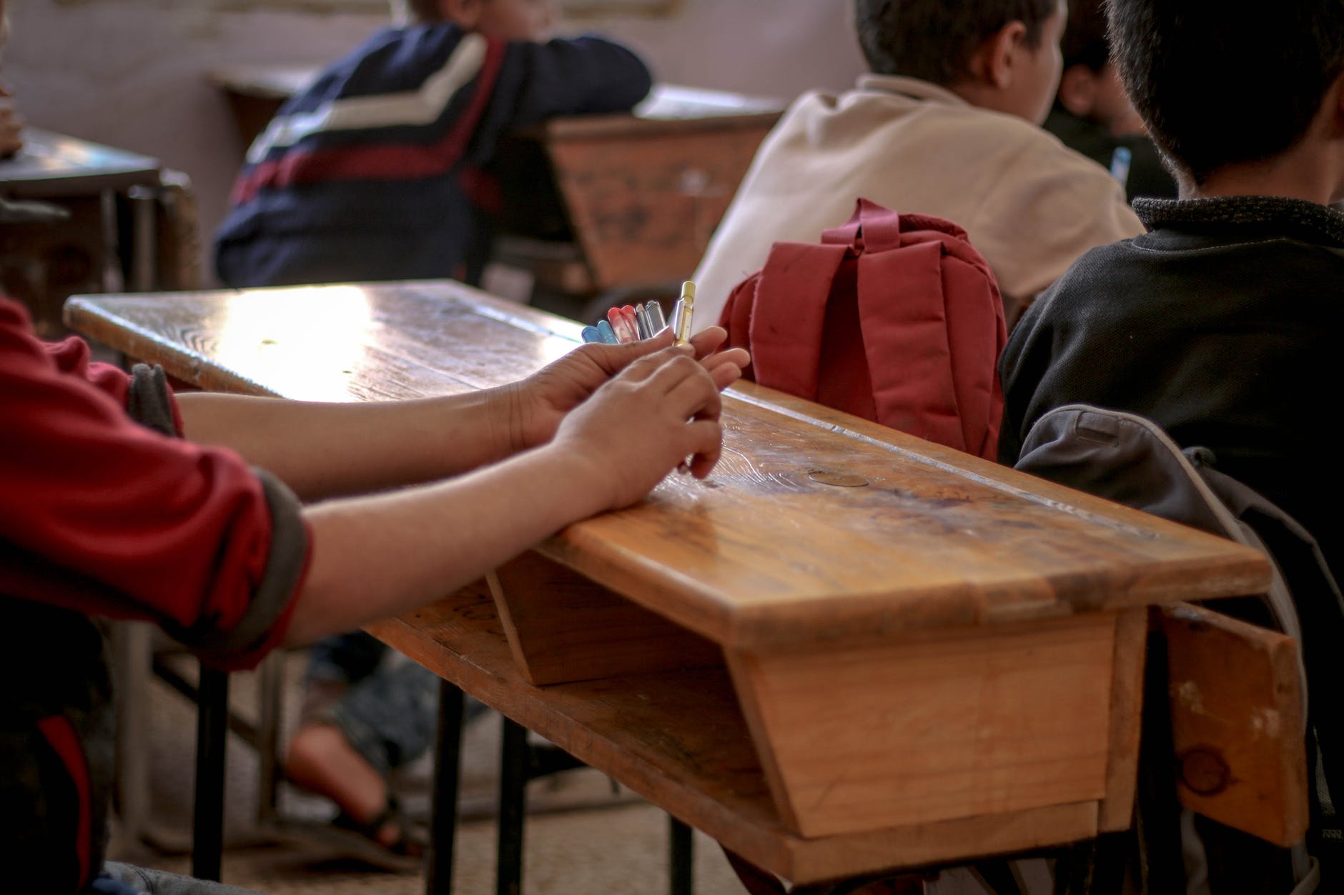 student s hands on a wooden table