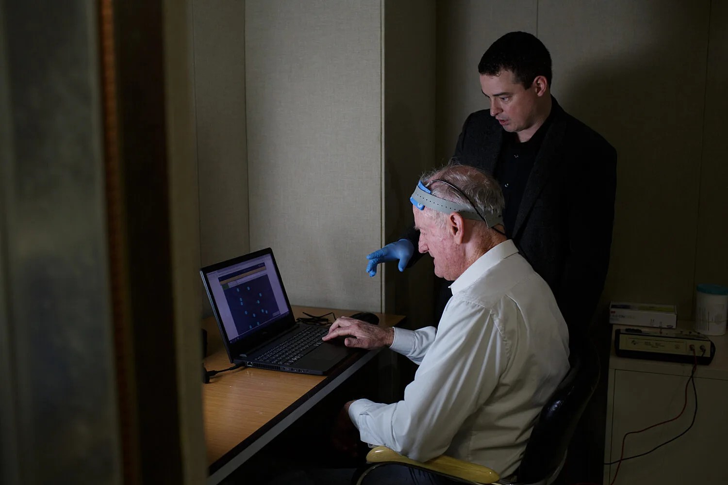 Dr. Adam Woods and a model participant demonstrate use of the tDCS device paired with computer-based cognitive training. Photo by Mindy C. Miller.