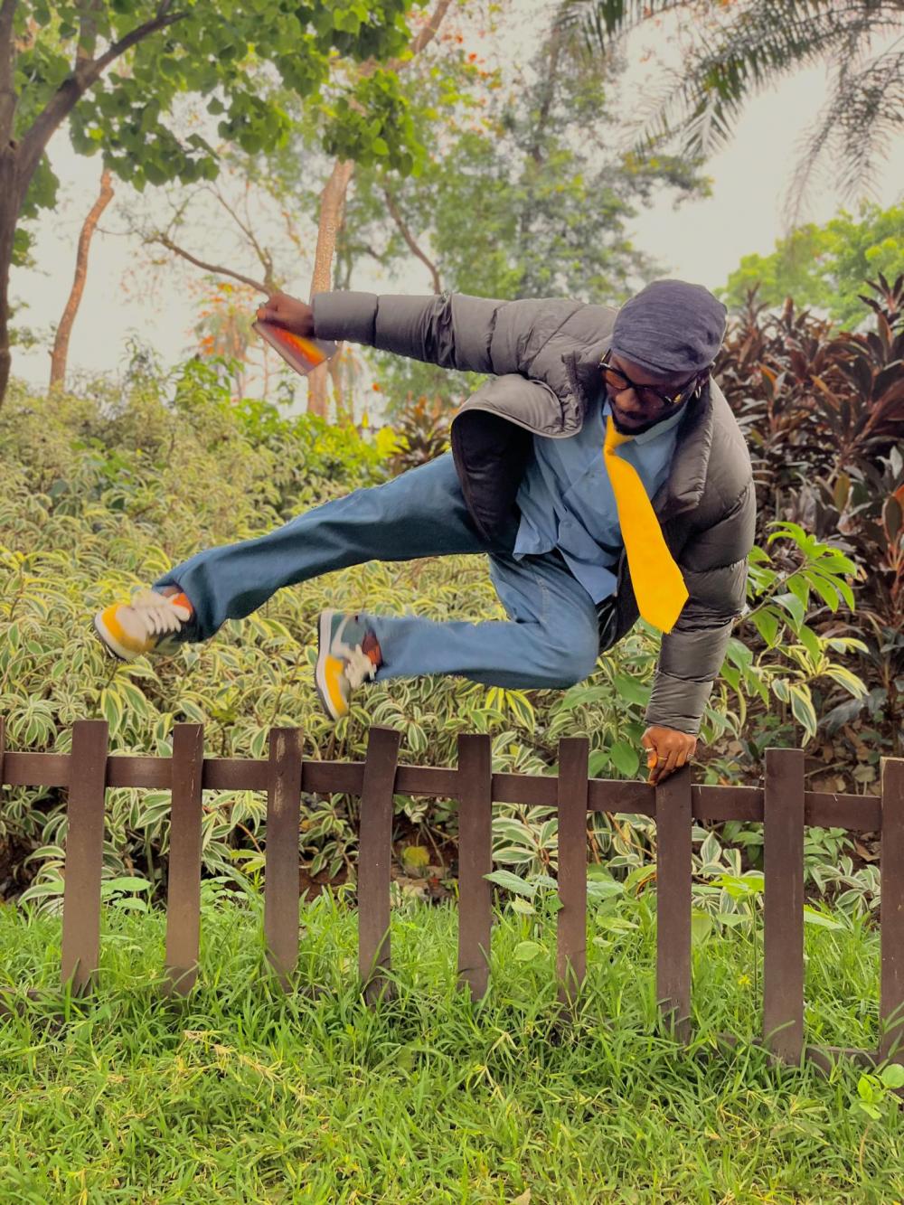 man in tie jumping over palisade fence