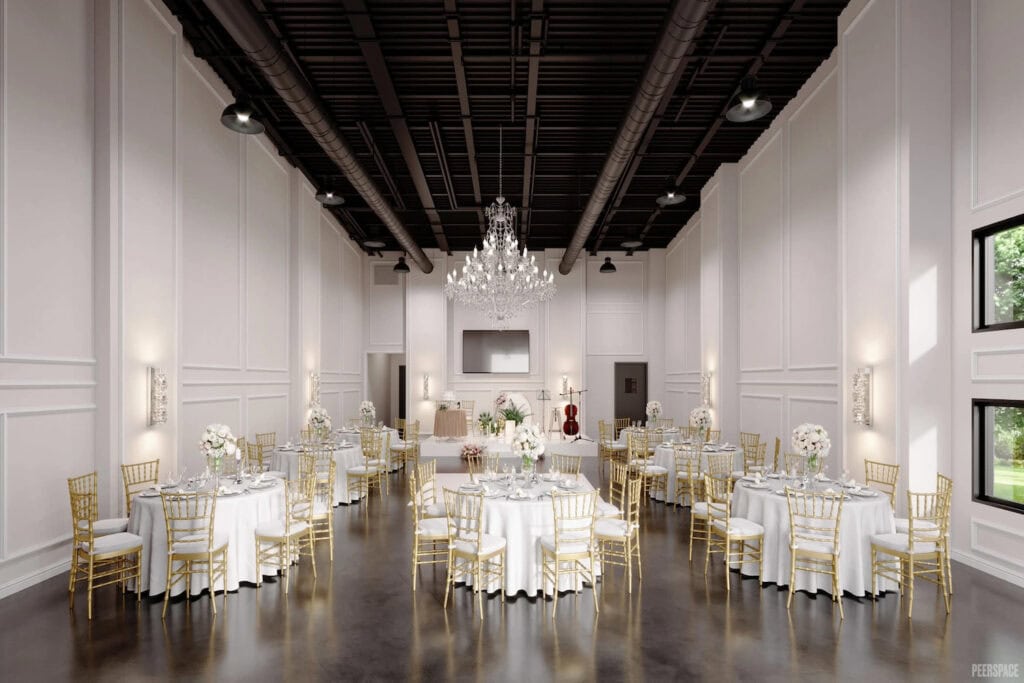 Gold chairs and white linens punctuate an elegant event space with black ceilings and white walls