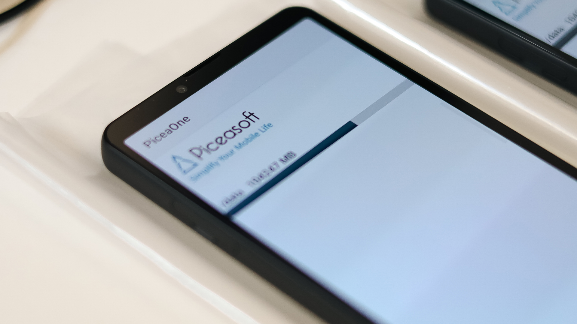 Multiple smartphones running Piceasoft PiceaOne data erasure software on a workbench, enabling secure mobile device wiping and kitting for refurbishment and resale.