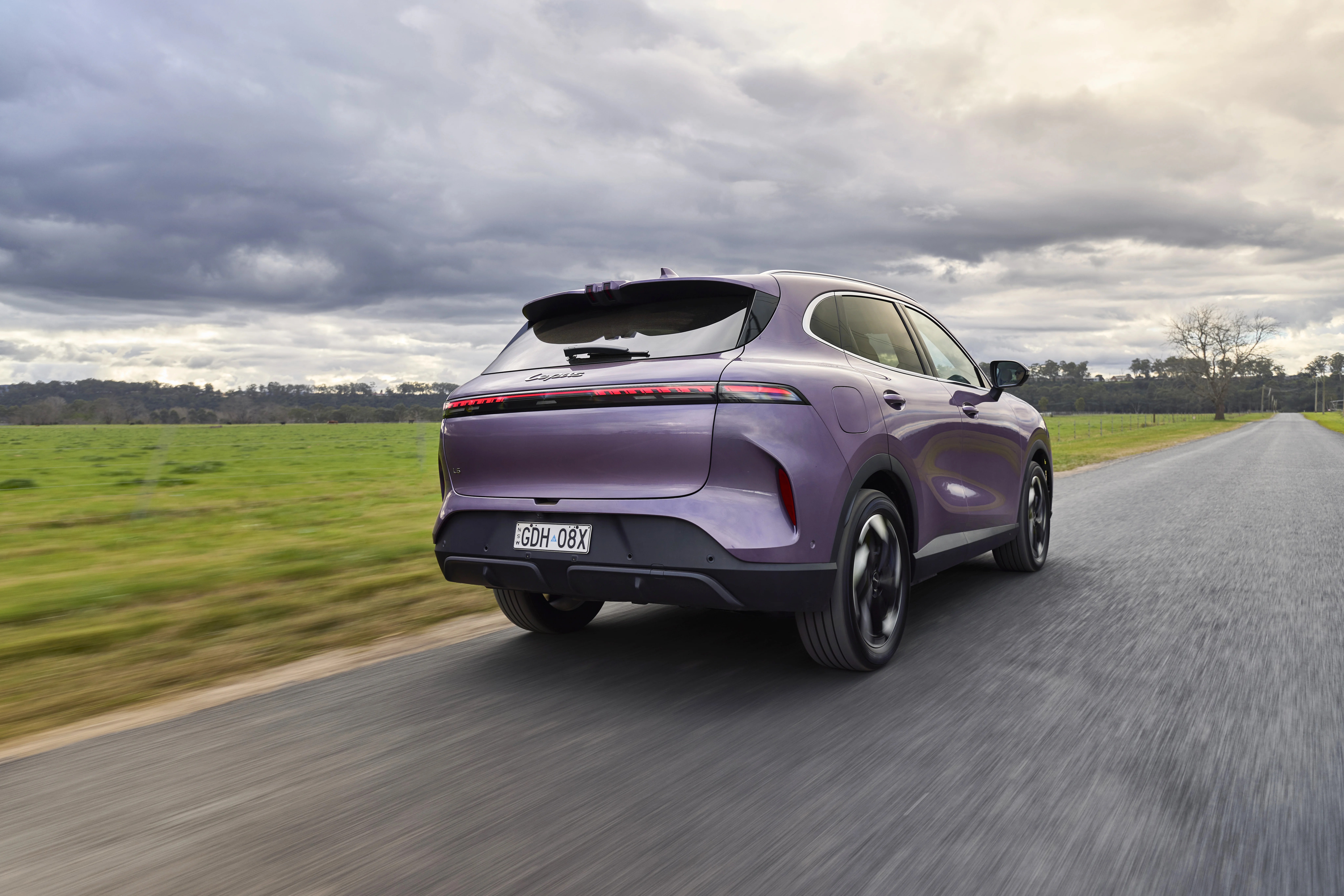 Purple SUV rear three-quarter on rural road