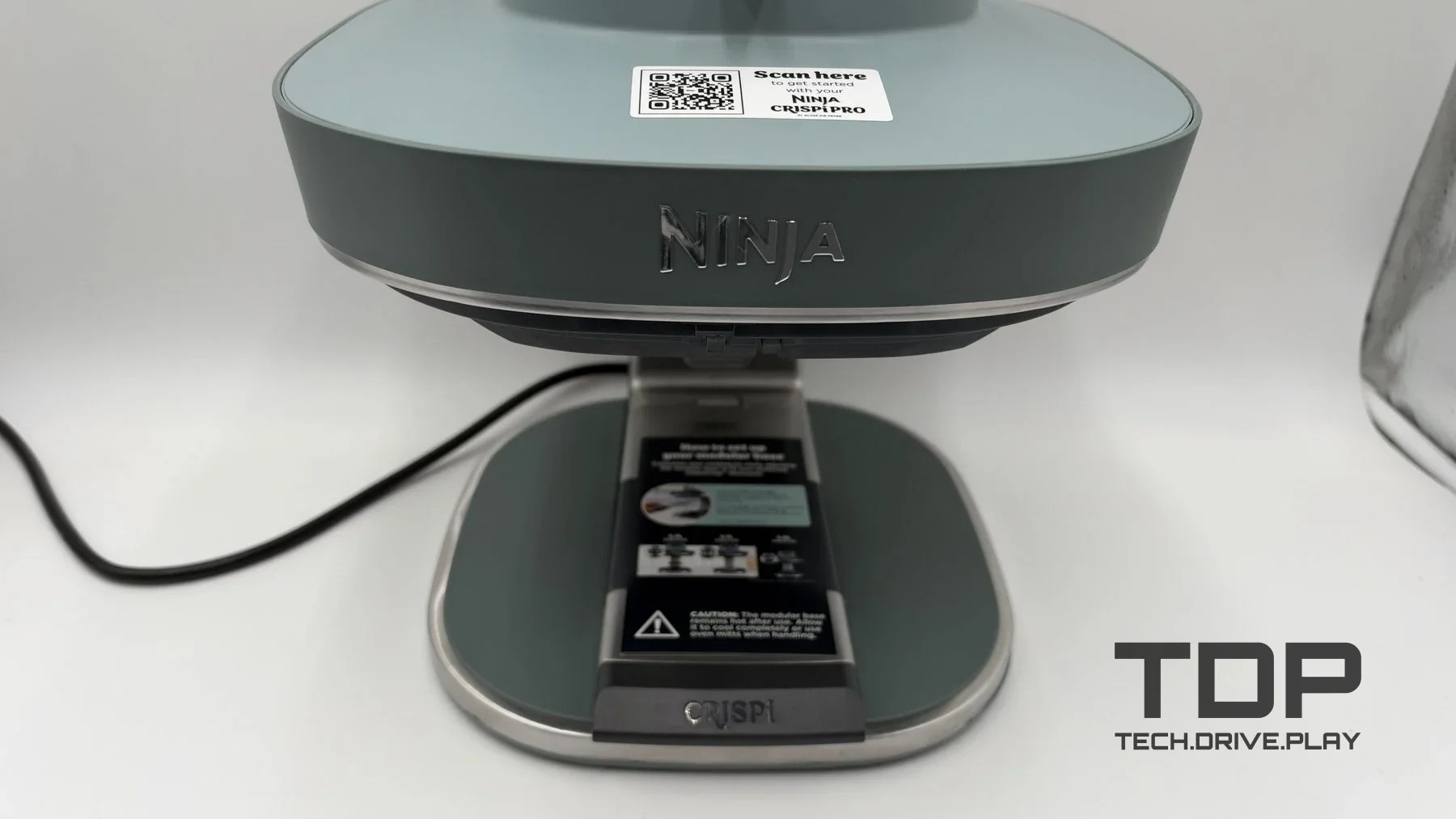 Green Ninja Crispi Pro cooking station with its glass container removed, showing the support base.
