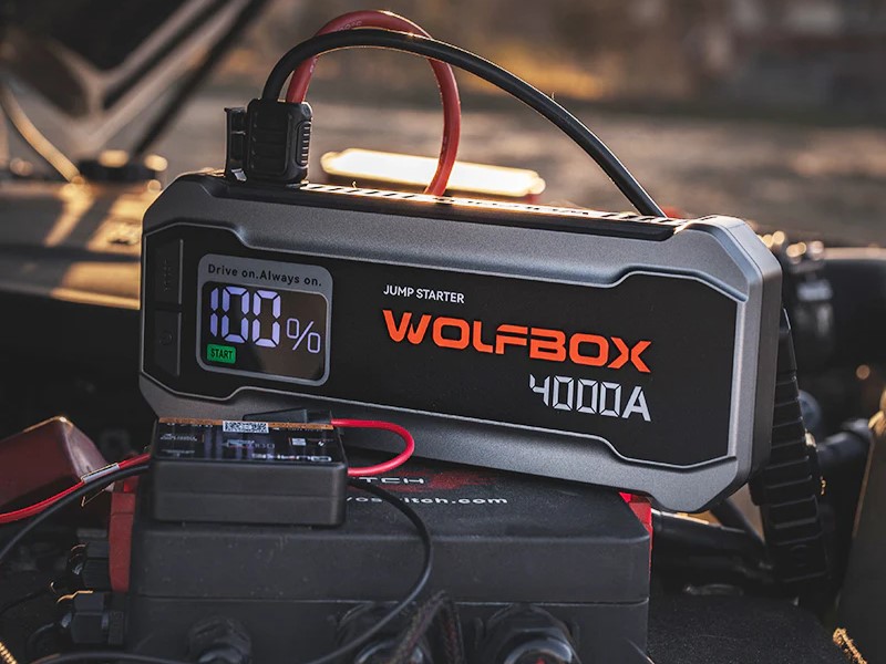 WOLFBOX MegaVolt24 portable jump starter in use with engine