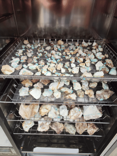 Rough turquoise drying on racks during the Tecolote Visions stabilization process