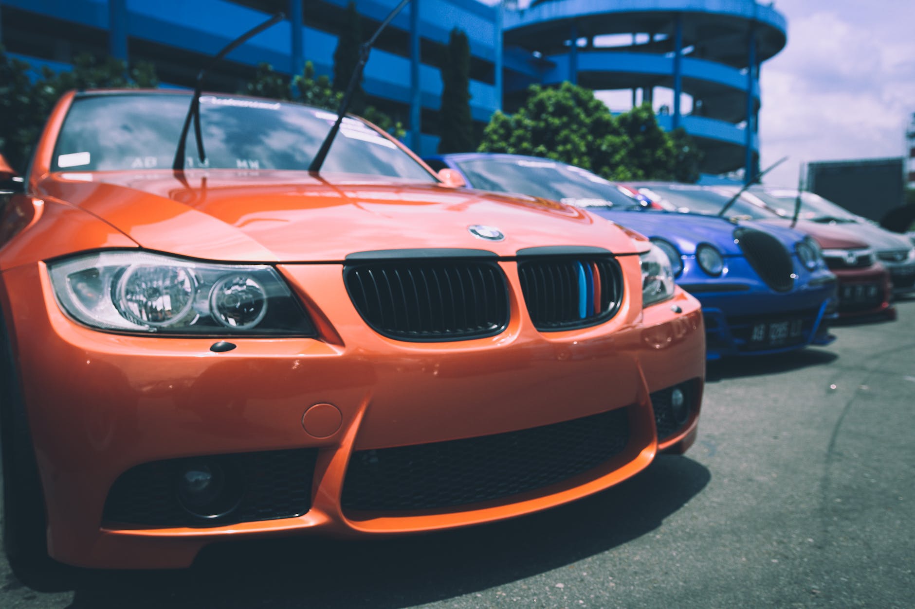 orange bmw car beside blue bugatti car
