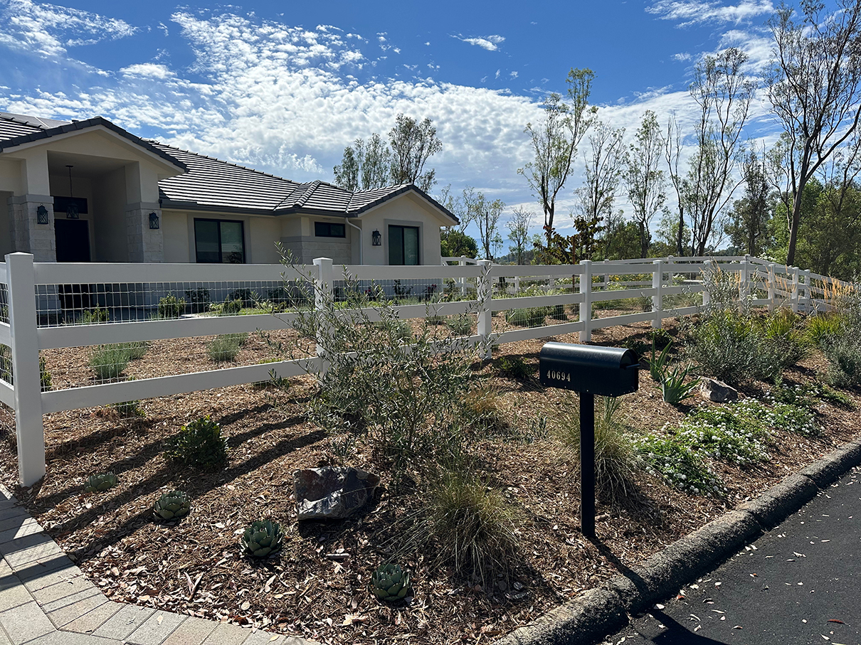 Shot of white fencing with chicken wire.