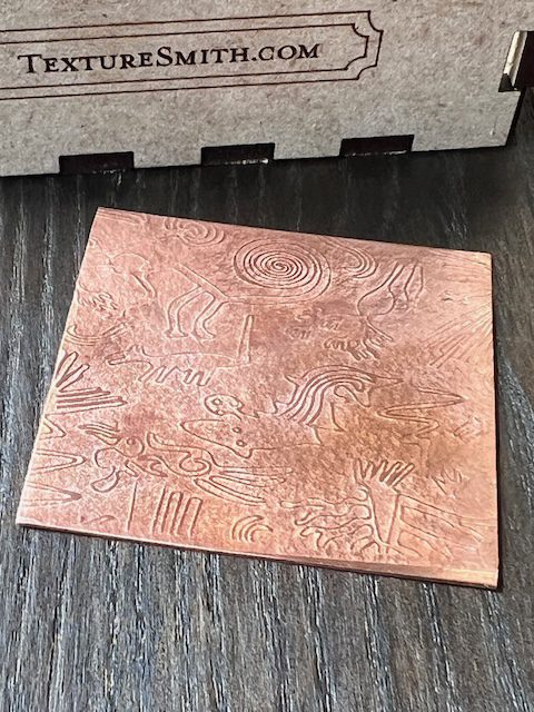 Copper sheet with abstract engraved patterns.