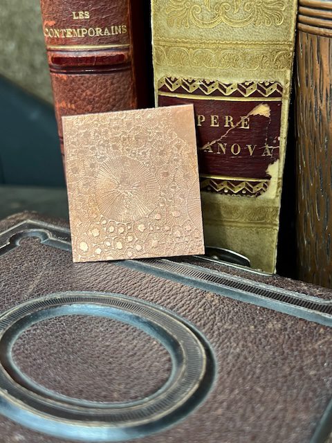 Antique books with decorative copper plate.
