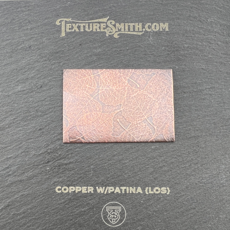 Copper sample with patina on black background.