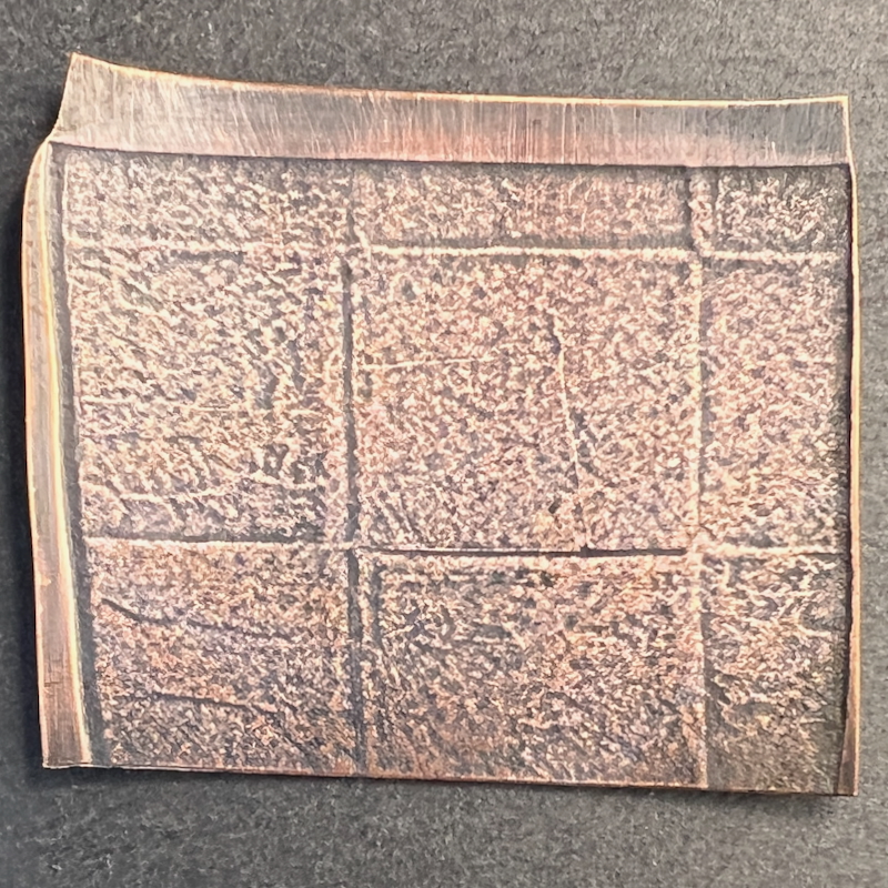 Ancient manuscript with engraved text lines.