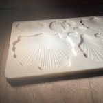 Shell-shaped silicone mold on wooden surface.
