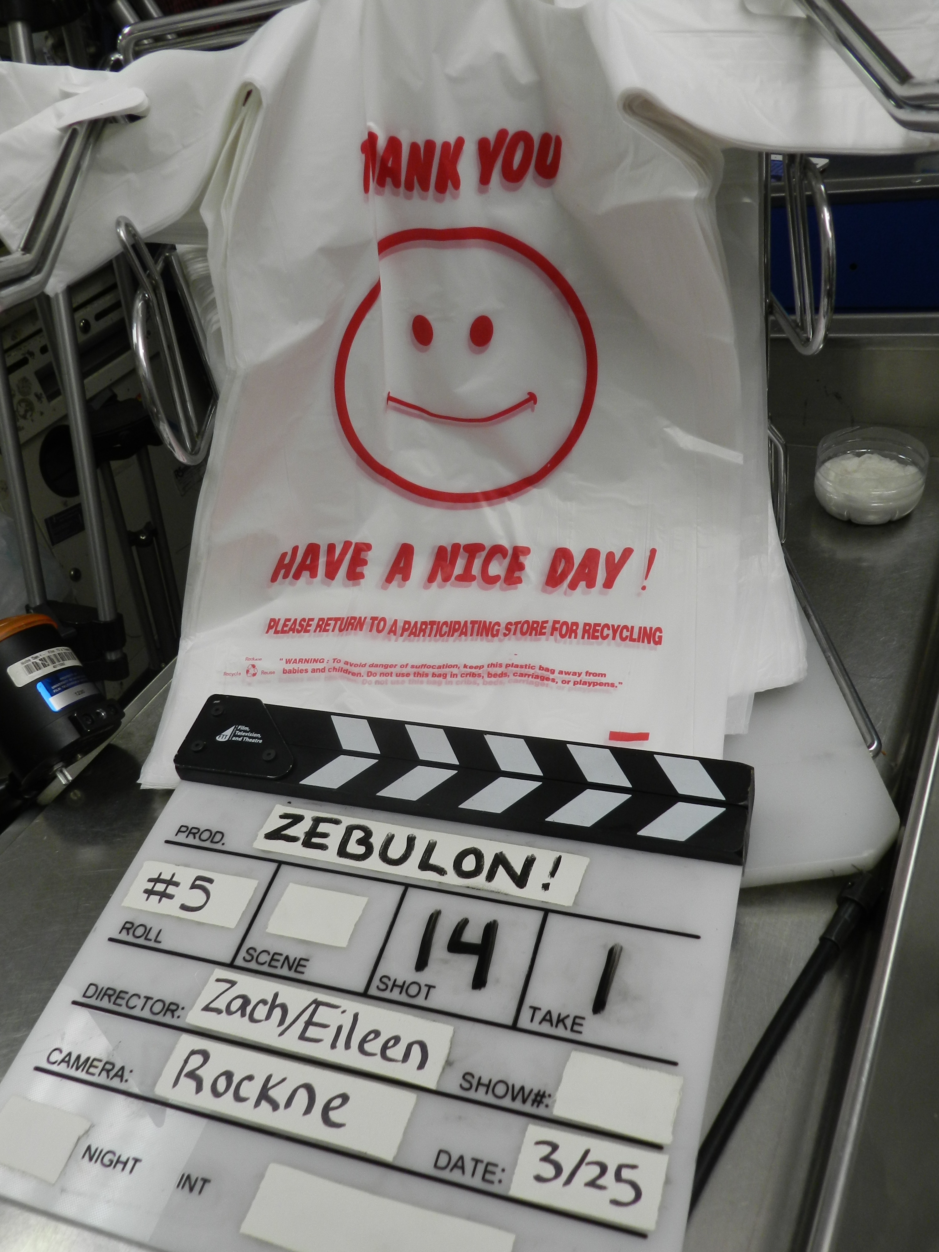 The slate lies next to a light and location prop from the market, waiting for its moment to mark the shot. After helping set up equipment, my entire job for the night was to change the slate and mark each shot. Slates can be marked entirely with the marker, or taped with the permanent information as above (deemed a "fancy slate" by one of the directors)