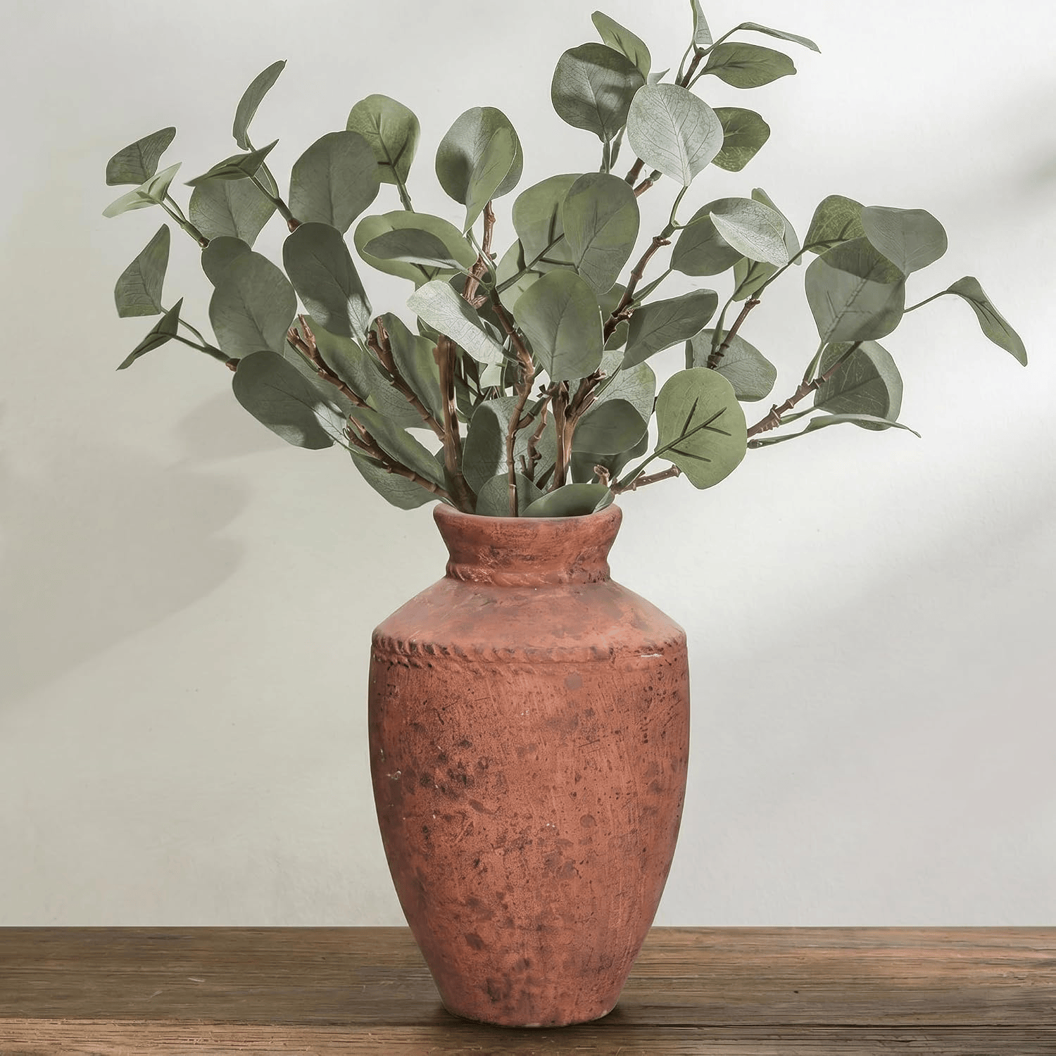 Terracotta vase styled with boho fall decor in warm earthy tones