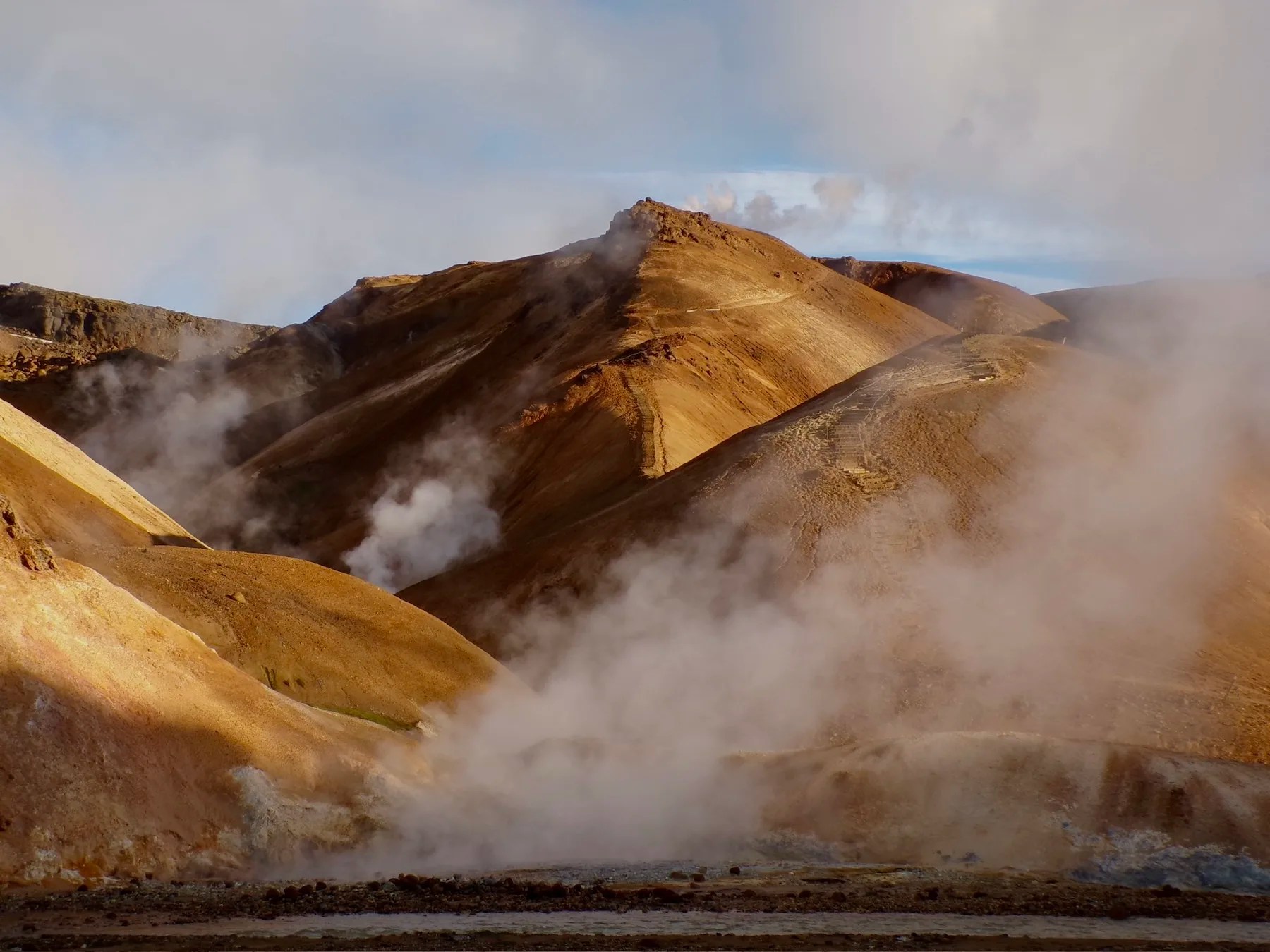 orange mountains of kerlingarfjoll in the highlands of iceland, with geothermal activity causing steam to rise all over the landscape