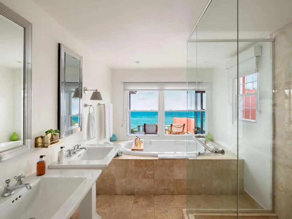 bathroom with a soaking tub and an ocean view at cambridge beaches resort and spa, bermuda