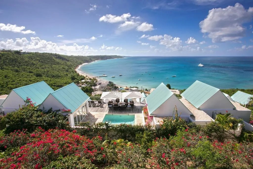 ceblue villas with turquoise roofs and a pool on the hillside above crocus bay in anguilla