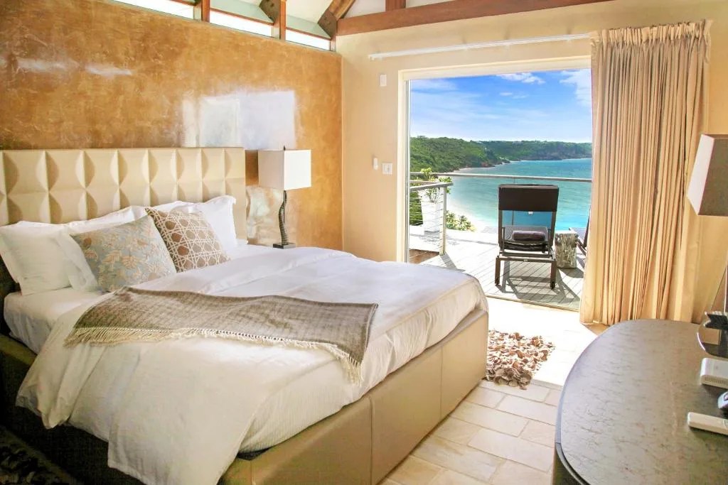 bedroom at ceblue villas in anguilla with a balcony looking out over crocus bay