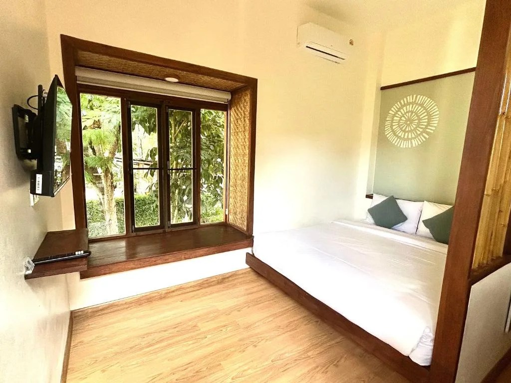 simple bungalow bedroom with a double bed and a large wooden window at pai country hut, pai