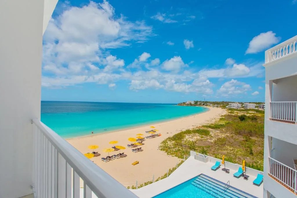 balcony overlooking a beautiful pool and stunning beach at turtles nest beach resort in anguilla