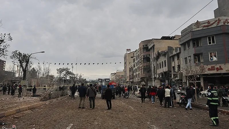 People gather on a damaged street near Shohada Square in Tehran after a strike, March 16, 2026