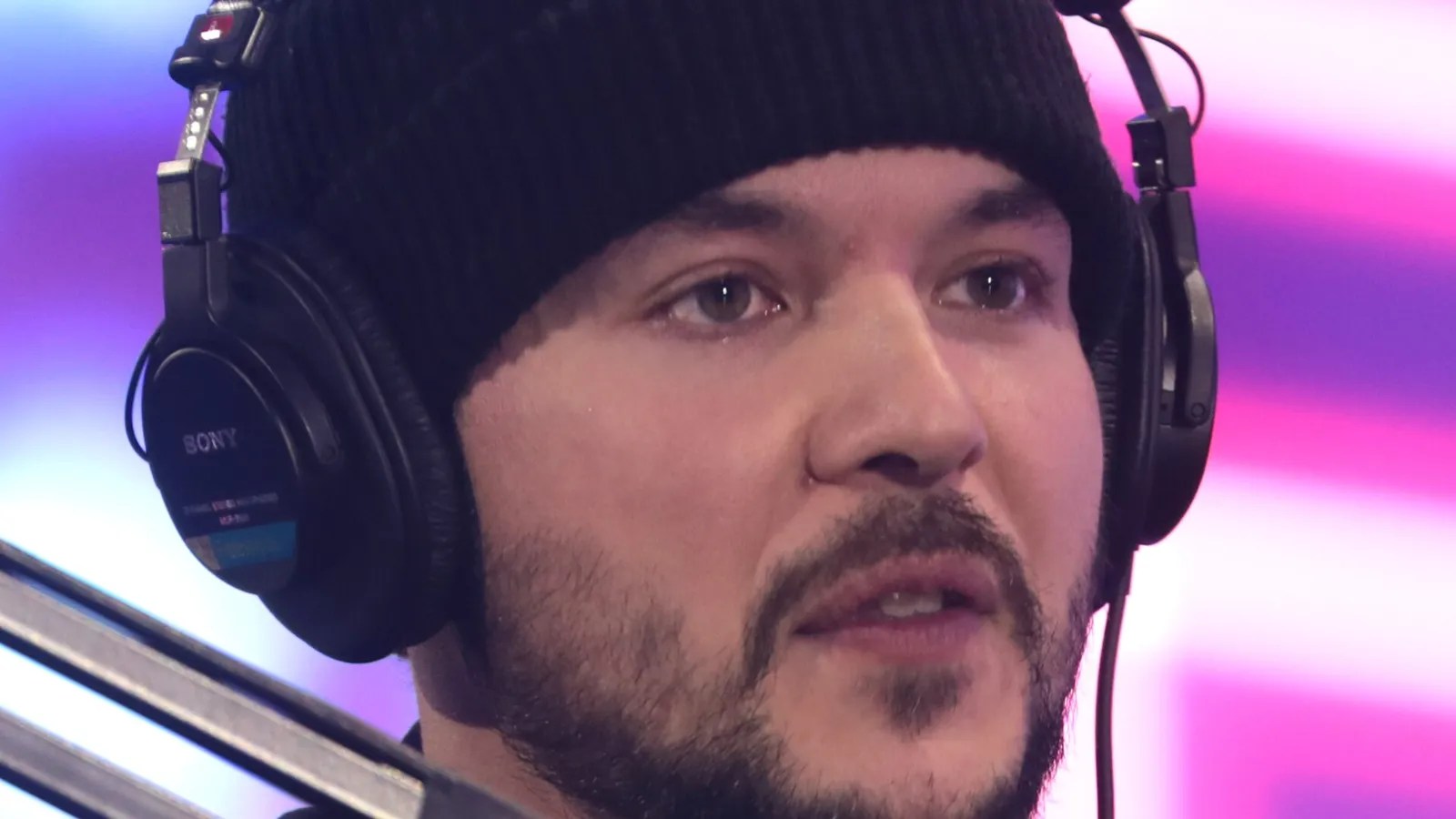 Tim Pool wearing a beanie and headphones at a microphone during the 2022 AmericaFest in Phoenix