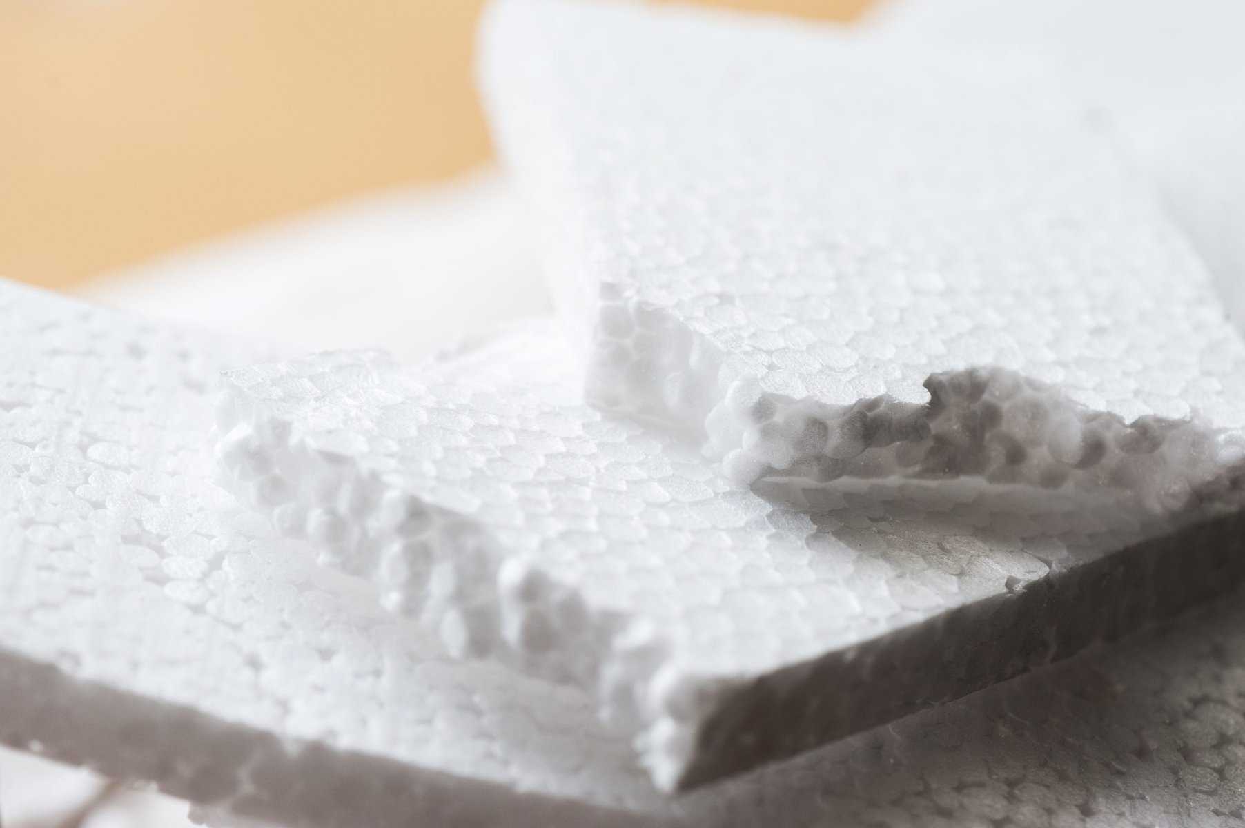 Closeup photo of white sytrofoam which you cannot compost, on top of cardboard.