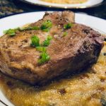 Sous vide pork chop on sun dried tomato and spinach polenta