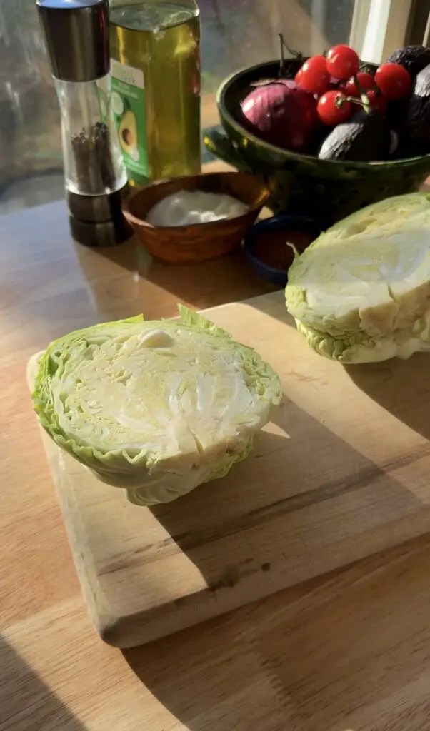 green cabbage cut in half on cutting board