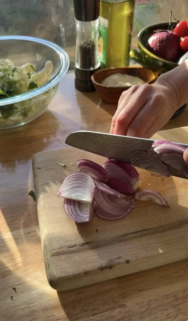 slicing red onion on cutting board