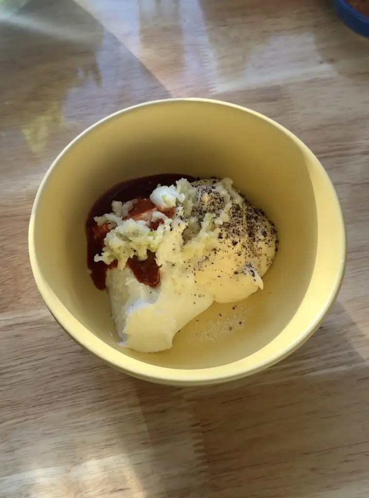 yellow bowl with minced garlic, sour cream, mayo, sriracha, lemon juice