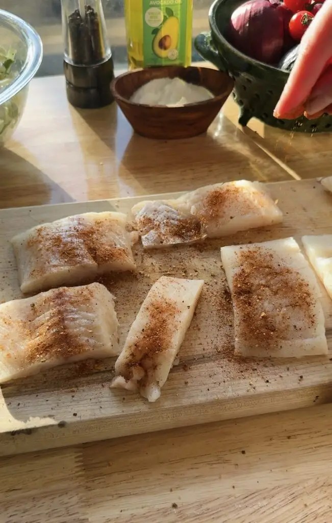 halibut filets with seasoning on cutting board